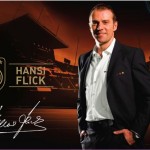 Mann in Geschäftskleidung steht vor einem Hintergrund mit Sportstadionlichtern und Deutschland-Branding-Elementen. Fritten, Fussball & Bier - www.soccer-warriors.de