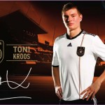 Ein Werbebild mit einem Fußballspieler im Trikot der deutschen Nationalmannschaft mit Branding-Elementen und einer Unterschrift mit der Überschrift „Auf gehts!“ Fritten, Fussball & Bier - www.soccer-warriors.de