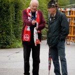 Zwei Männer unterhalten sich auf einer Straße, einer davon trägt einen Sportschal des 1. FC Nürnberg. Fritten, Fussball & Bier - www.soccer-warriors.de