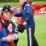 Einzelpersonen bei einem Sporttraining, mit einer Person im Fokus, die mit einem Fußball im Hintergrund trainiert und sich auf ein Testspiel gegen Racing Santander vorbereitet. Fritten, Fussball & Bier - www.soccer-warriors.de