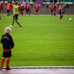 Junger Fußballspieler des 1. FC Nürnberg beobachtet seine Teamkollegen beim Aufwärmen auf dem Spielfeld vor einem Testspiel gegen Racing Santander. Fritten, Fussball & Bier - www.soccer-warriors.de