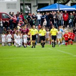 Fußballspieler und Schiedsrichter betreten mit Kindern das Spielfeld, im Hintergrund Zuschauer während eines Testspiels zwischen Racing Santander und dem 1. FC Nürnberg. Fritten, Fussball & Bier - www.soccer-warriors.de