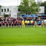 Fußballmannschaften des 1. FC Nürnberg und Racing Santander sowie Schiedsrichter stehen vor Beginn eines Testspiels auf dem Spielfeld. Fritten, Fussball & Bier - www.soccer-warriors.de
