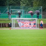 Ein regnerischer Tag auf einem Fußballplatz mit Zuschauern mit Regenschirmen und einem Torwart, der am Netz steht, während eines Testspiels zwischen dem 1. FC Nürnberg und Racing Santander. Fritten, Fussball & Bier - www.soccer-warriors.de