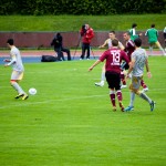 Fußballspieler des FC Nürnberg und Racing Santander sind während eines Testspiels auf einem grünen Spielfeld im Einsatz, wobei ein Spieler den Ball kontrolliert. Fritten, Fussball & Bier - www.soccer-warriors.de