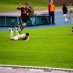 Fußballspieler von Racing Santander fällt mit dem Ball auf das Spielfeld, während Gegner vom 1. FC Nürnberg und Zuschauer bei einem Testspiel zusehen. Fritten, Fussball & Bier - www.soccer-warriors.de