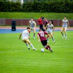 Fußballspieler von Racing Santander und 1. FC Nürnberg im Einsatz während eines Testspiels, wobei ein Spieler die Ballkontrolle übernimmt, während die Gegner näherkommen. Fritten, Fussball & Bier - www.soccer-warriors.de