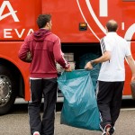 Zwei Personen tragen einen Müllsack neben einem Racing Santander-Bus. Fritten, Fussball & Bier - www.soccer-warriors.de