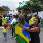 Gruppe von Menschen mit brasilianischen Flaggen, die an einer festlichen Straßenversammlung teilnehmen, um Brasilien gegen Schweden anzufeuern. Fritten, Fussball & Bier - www.soccer-warriors.de